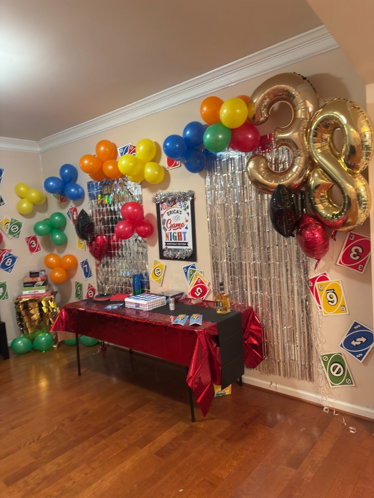 Party setup with red table, gold number 38 balloons, and casino decorations.