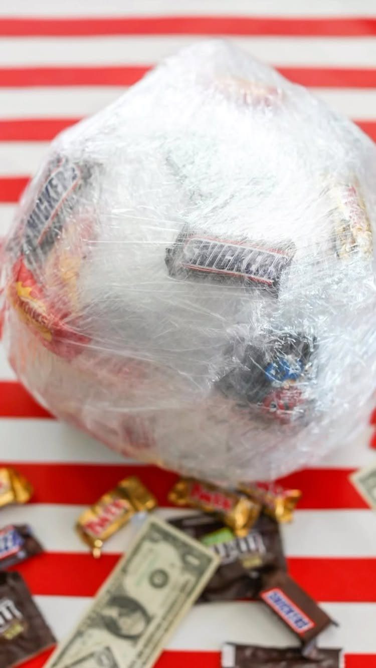 Ball of candy wrapped in plastic cling wrap on red and white stripes