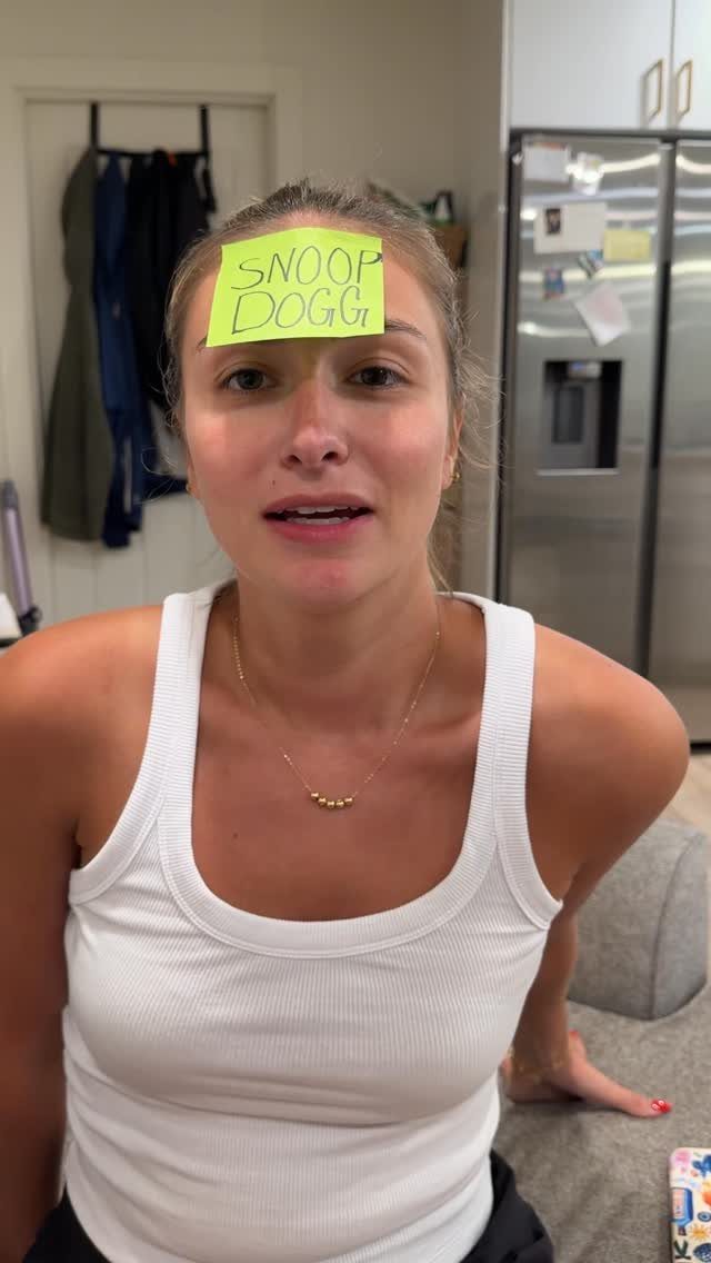 Woman with a yellow sticky note saying Snoop Dogg on her forehead.