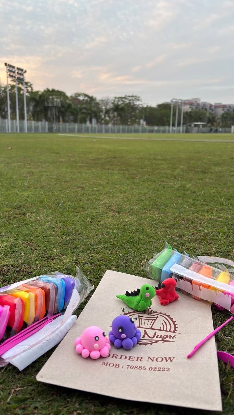 Colorful clay dinosaur figures and modeling clay on grass for a creative date.