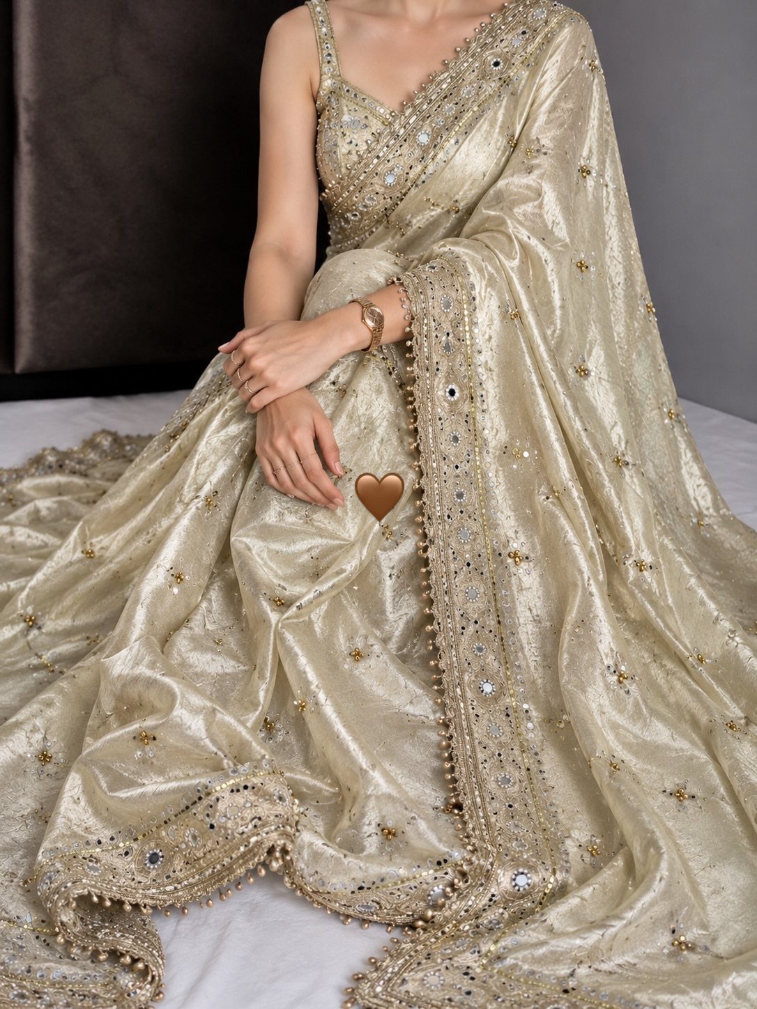 Gold silk saree with intricate embroidery and mirror work draped on a person.