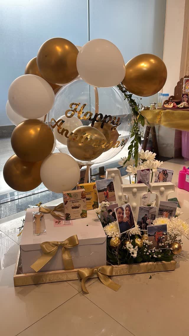 Gold and white balloons with a Happy Anniversary clear balloon and photo display.