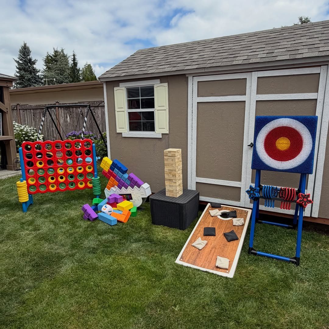 Giant Connect Four and other oversized lawn games set up on a grassy yard.