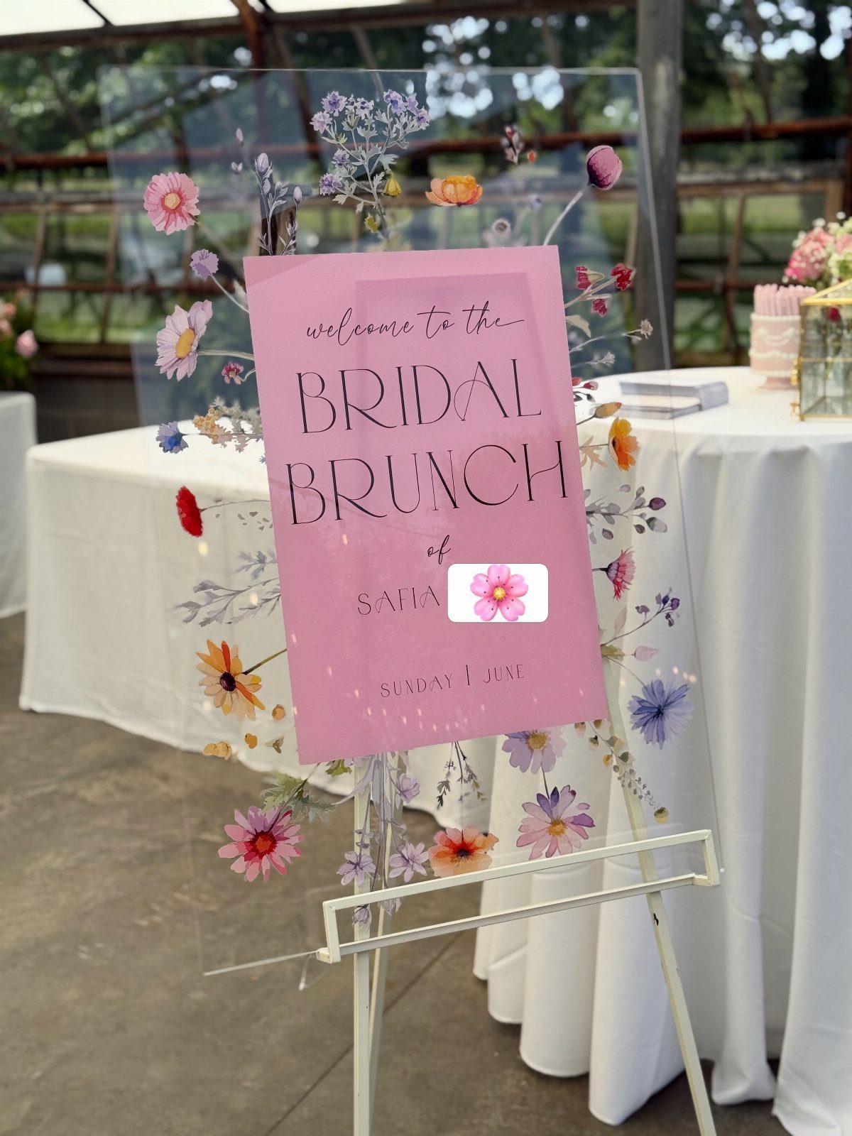Acrylic welcome sign for a bridal brunch with floral designs on a white easel