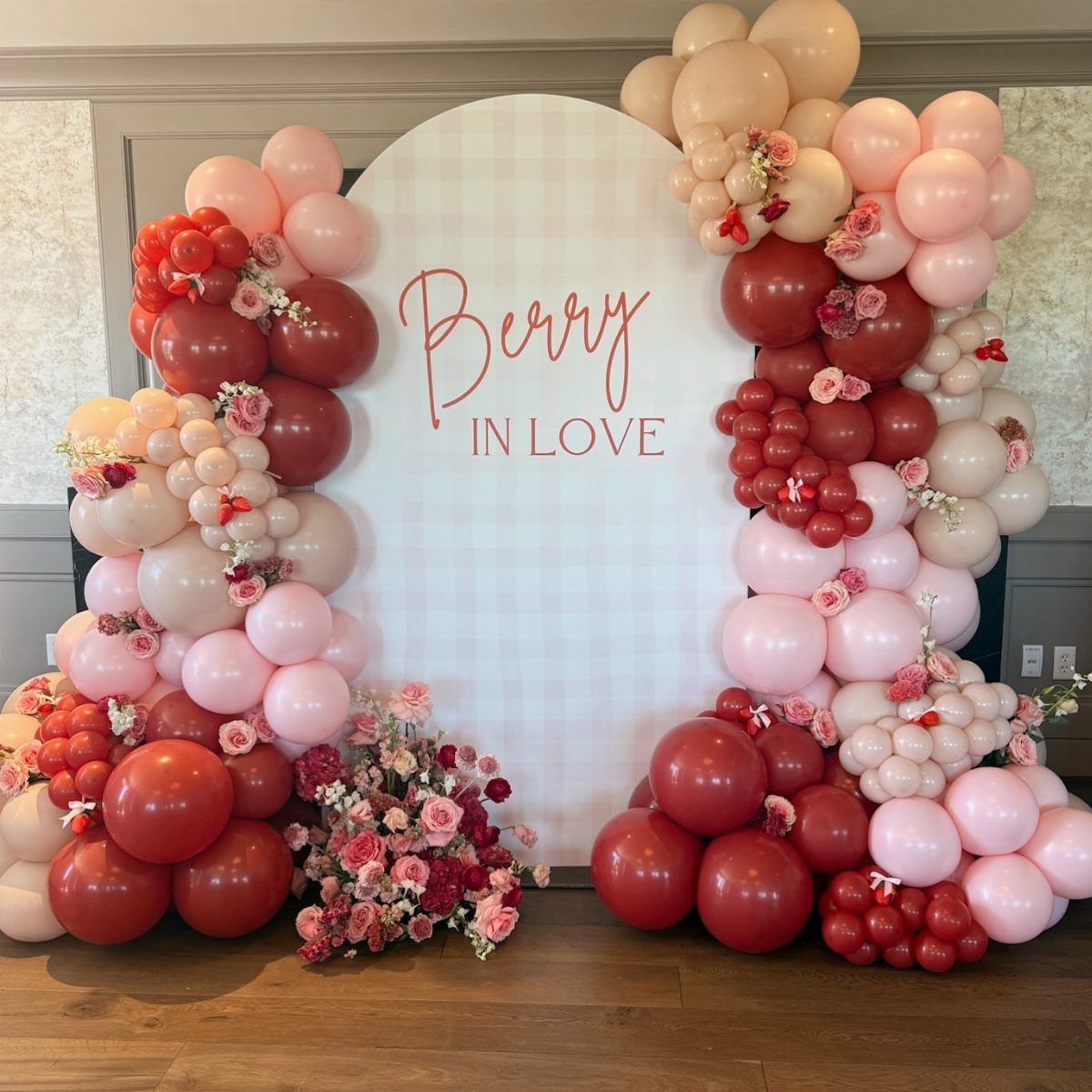 Berry in Love backdrop with red and pink balloons and floral accents