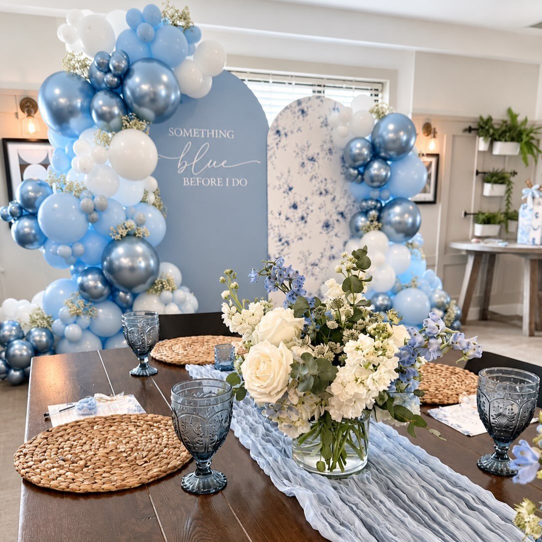 Blue and white balloon arch and table setting for a bridal shower.