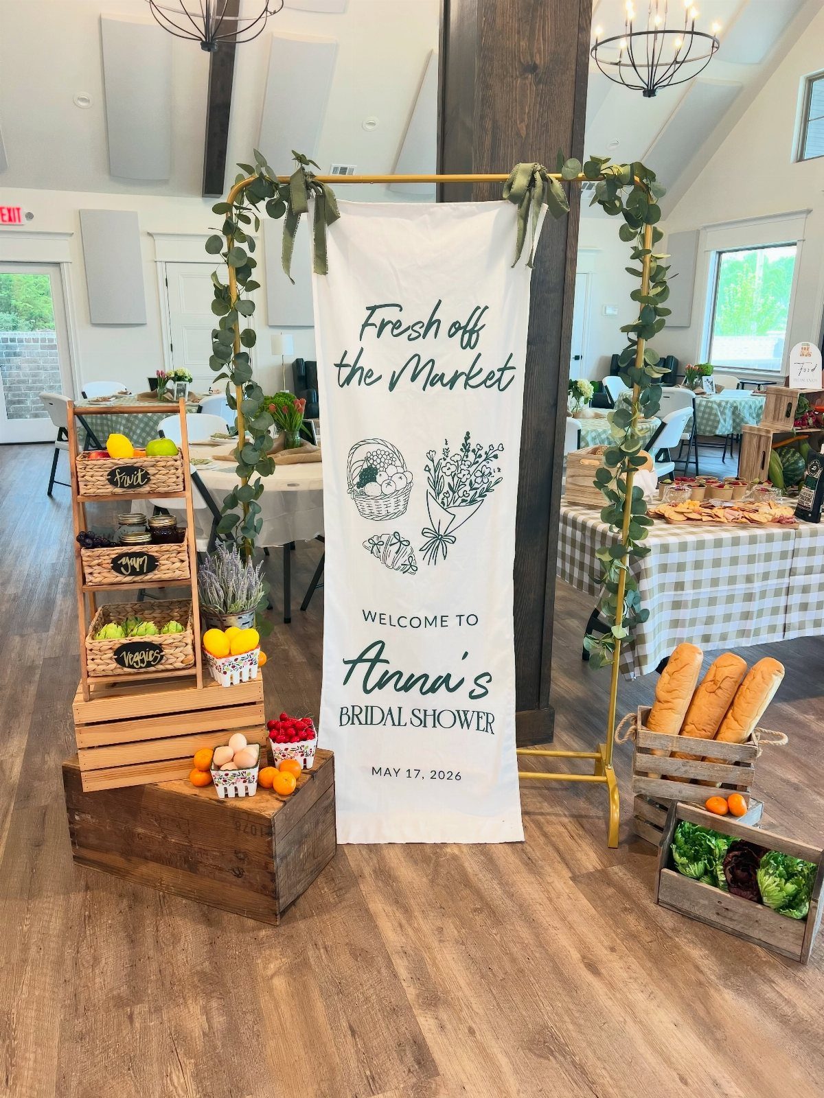 Farmers market themed bridal shower welcome sign with wooden crates of fresh produce.