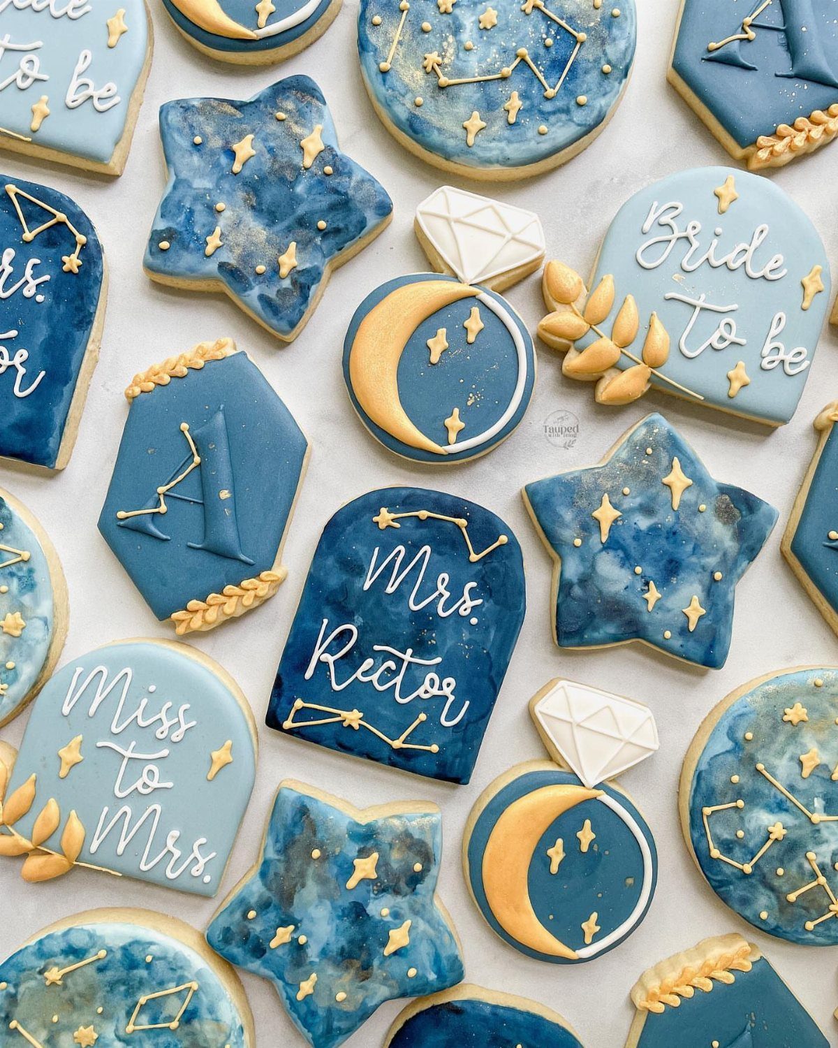 Blue and gold celestial themed cookies with stars, moons, and bridal text.