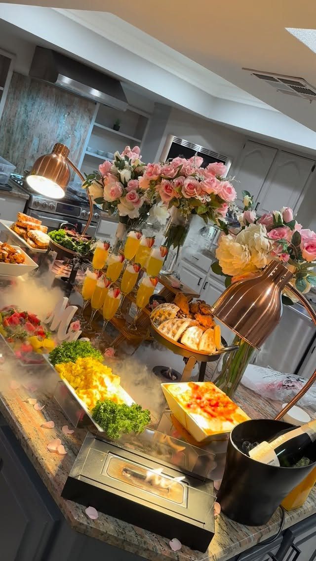 Lavish brunch spread with scrambled eggs, orange juice, and pink roses on a counter.