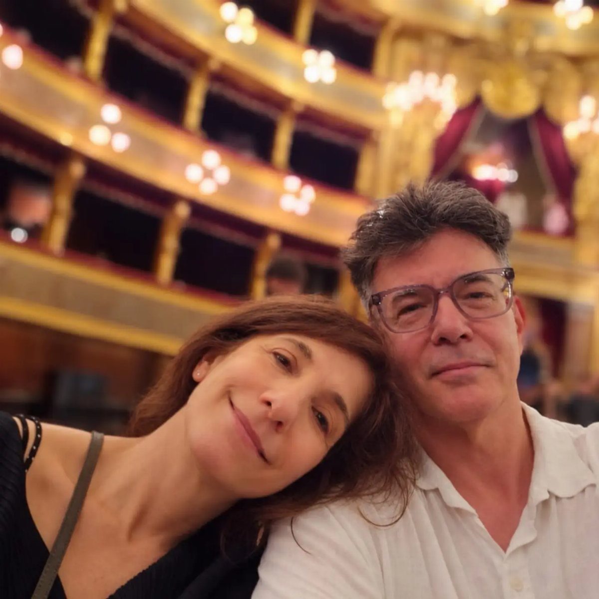 Couple smiling for a selfie inside a lavish, gold-decorated historic theater venue.