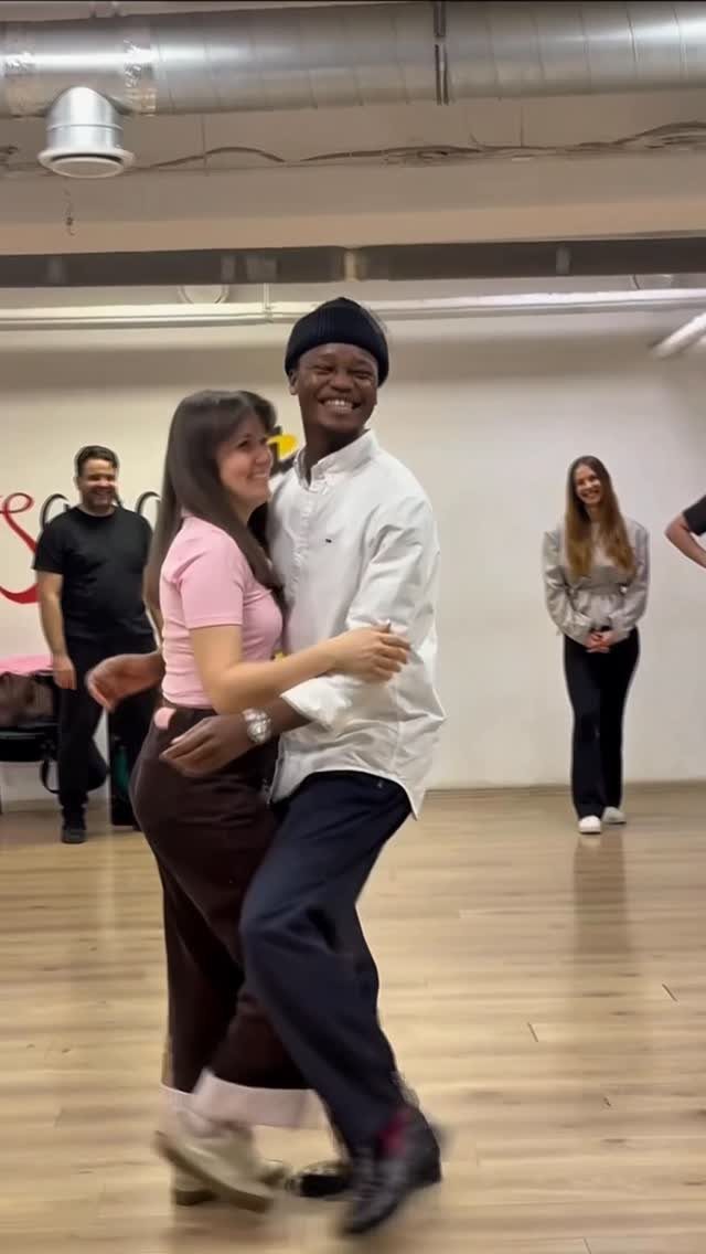 A man and woman dancing together in a bright dance studio.