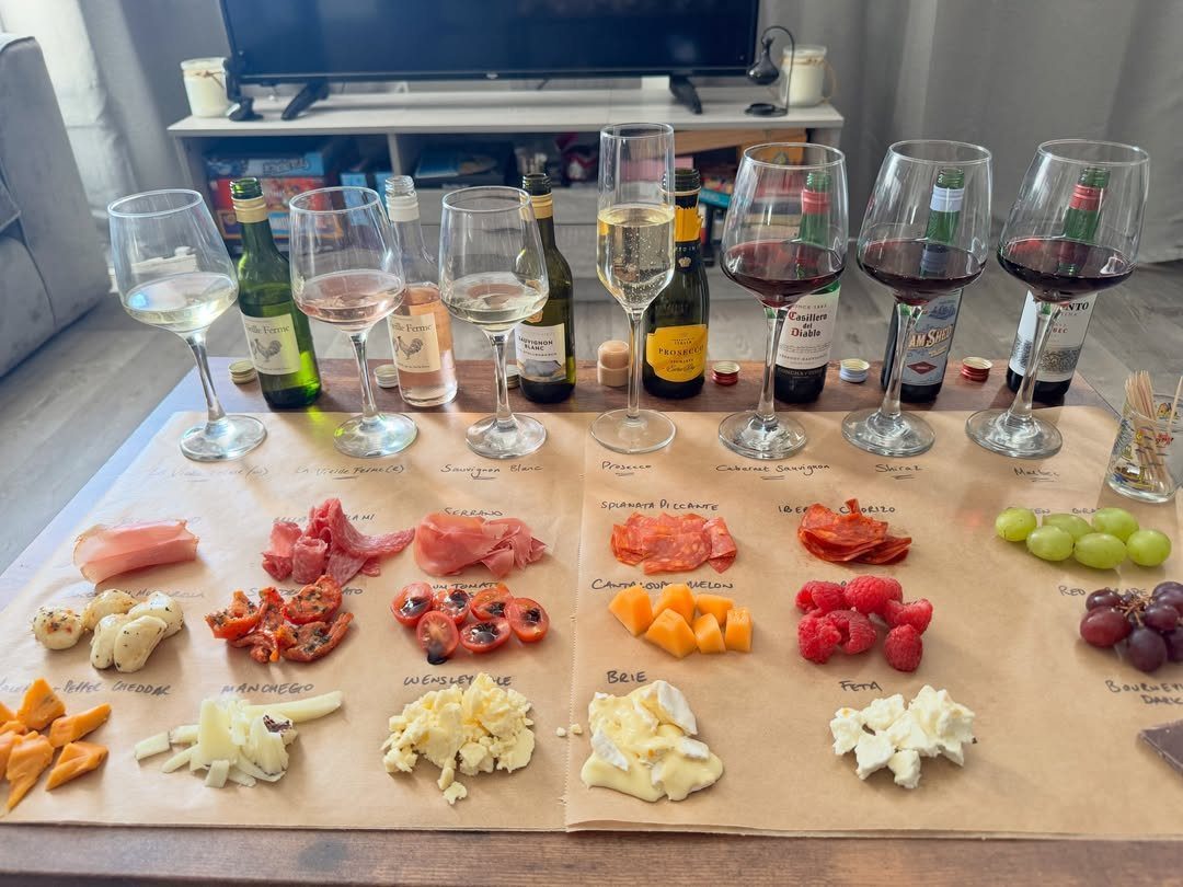 Wine tasting spread with various glasses of wine and a charcuterie board.