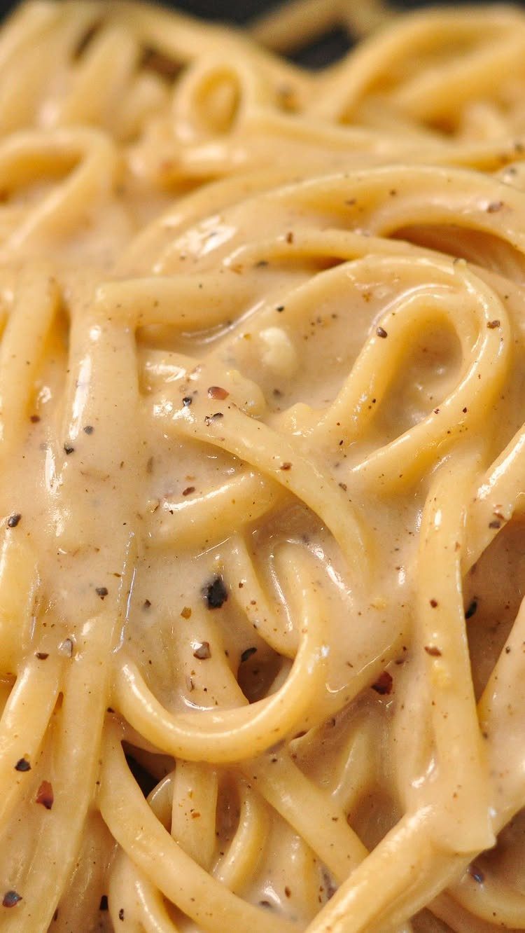 Creamy pasta noodles coated in cheese sauce and cracked black pepper.