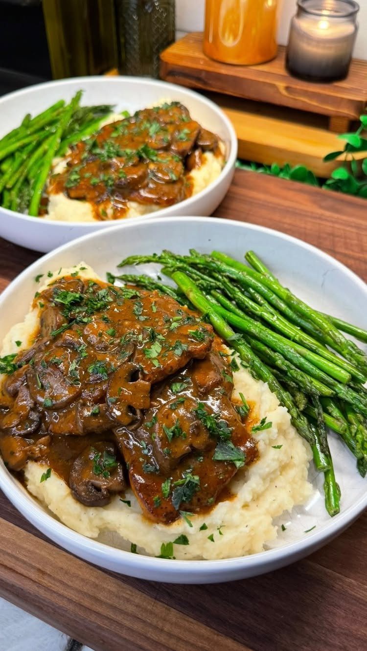 Meat with mushroom gravy served over mashed potatoes with steamed green asparagus.