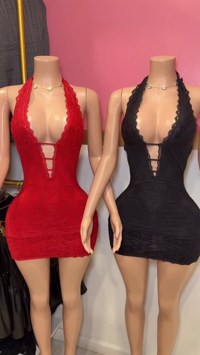 Two mannequins wearing lace-trimmed mini dresses in red and black colors.
