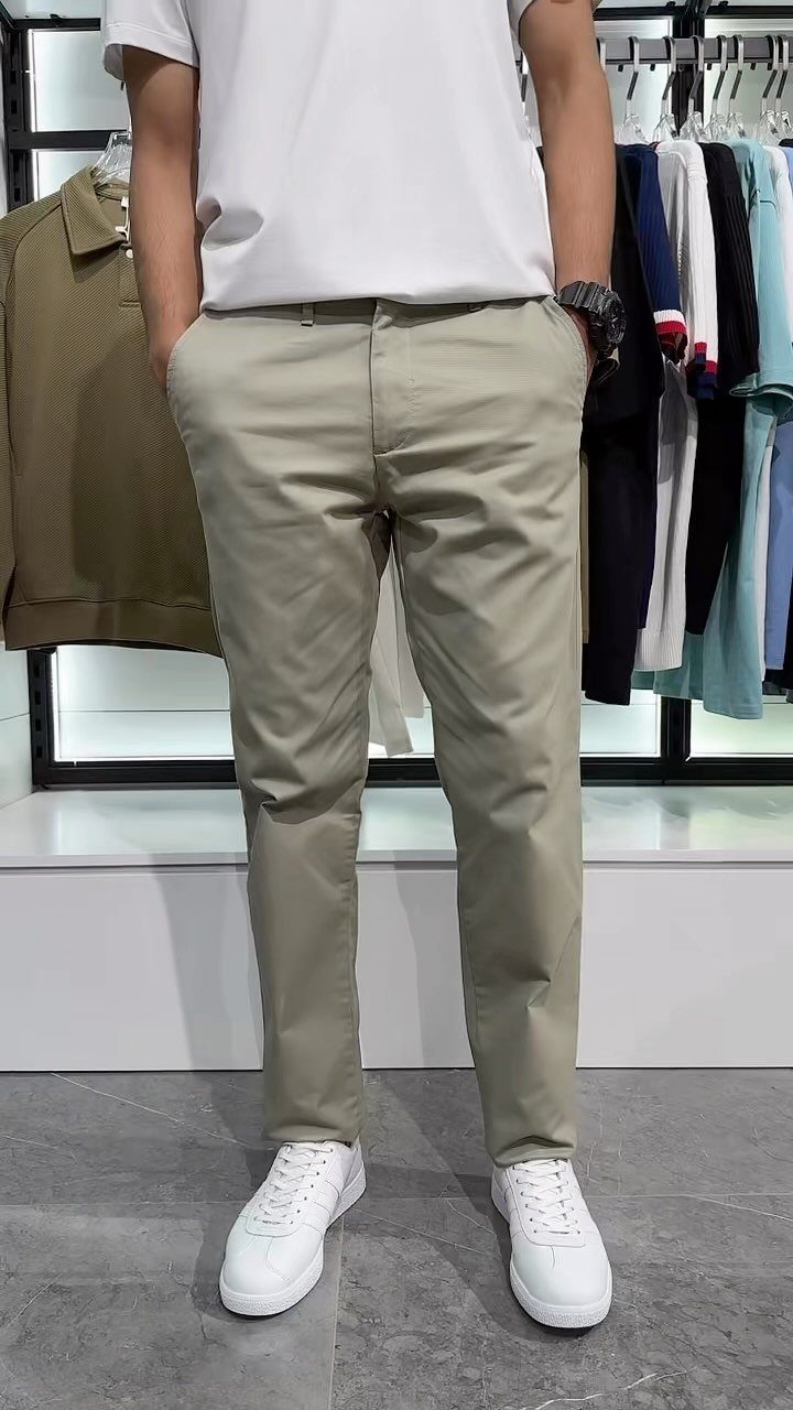 Man wearing a white t-shirt, khaki chinos, and white sneakers in a store