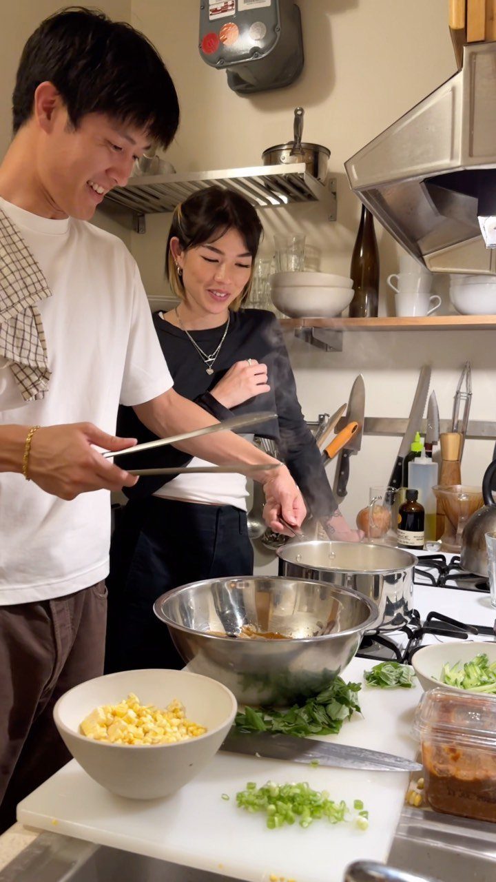 Couple cooking a meal together in a kitchen with fresh ingredients on the counter
