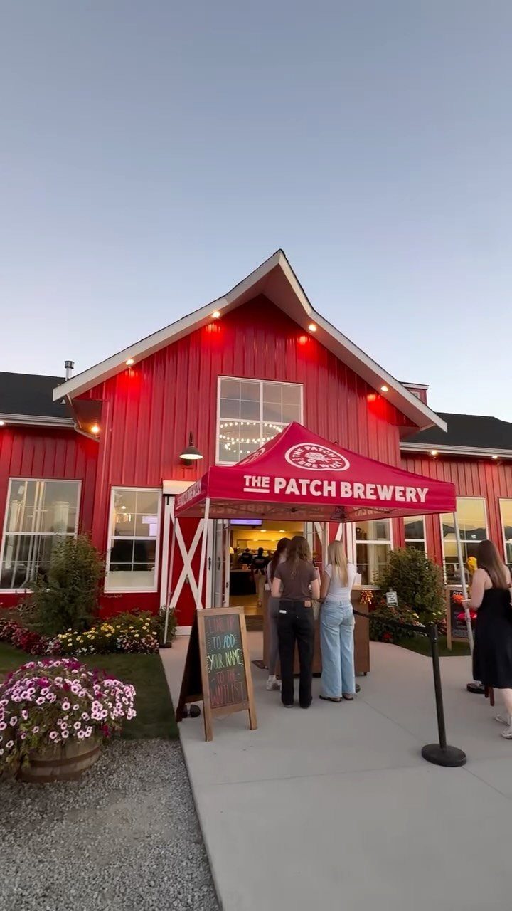 The Patch Brewery red barn building with people queuing under a red awning.