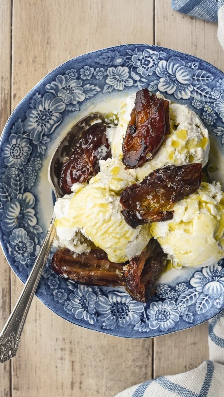 Vanilla ice cream with caramelized bananas in a blue floral bowl on wood.