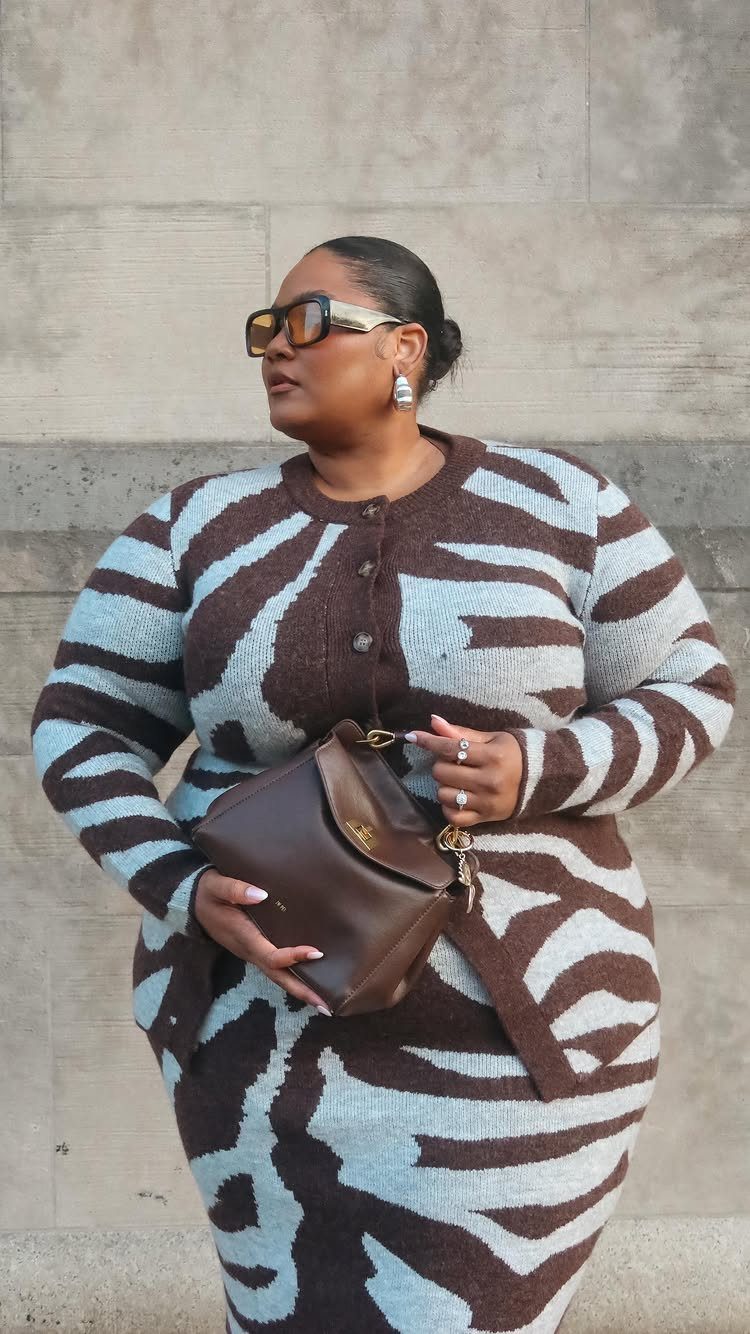 Plus-size woman in a brown and blue zebra print knit cardigan and skirt set.