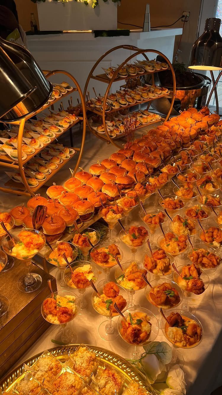 Buffet table with sliders and appetizers in glasses for a home party.