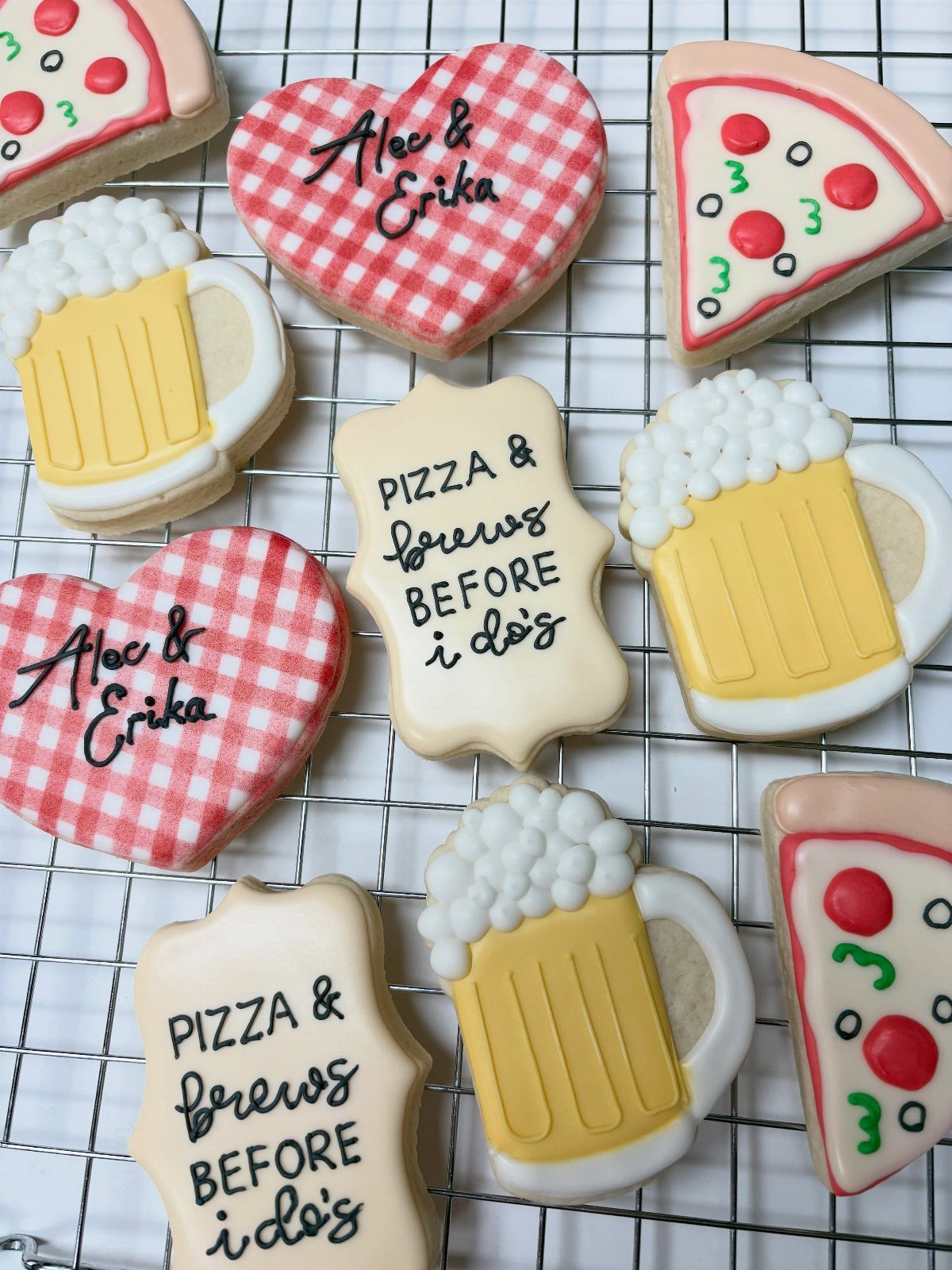 Iced sugar cookies shaped like beer mugs, pizza slices, and hearts on a rack.