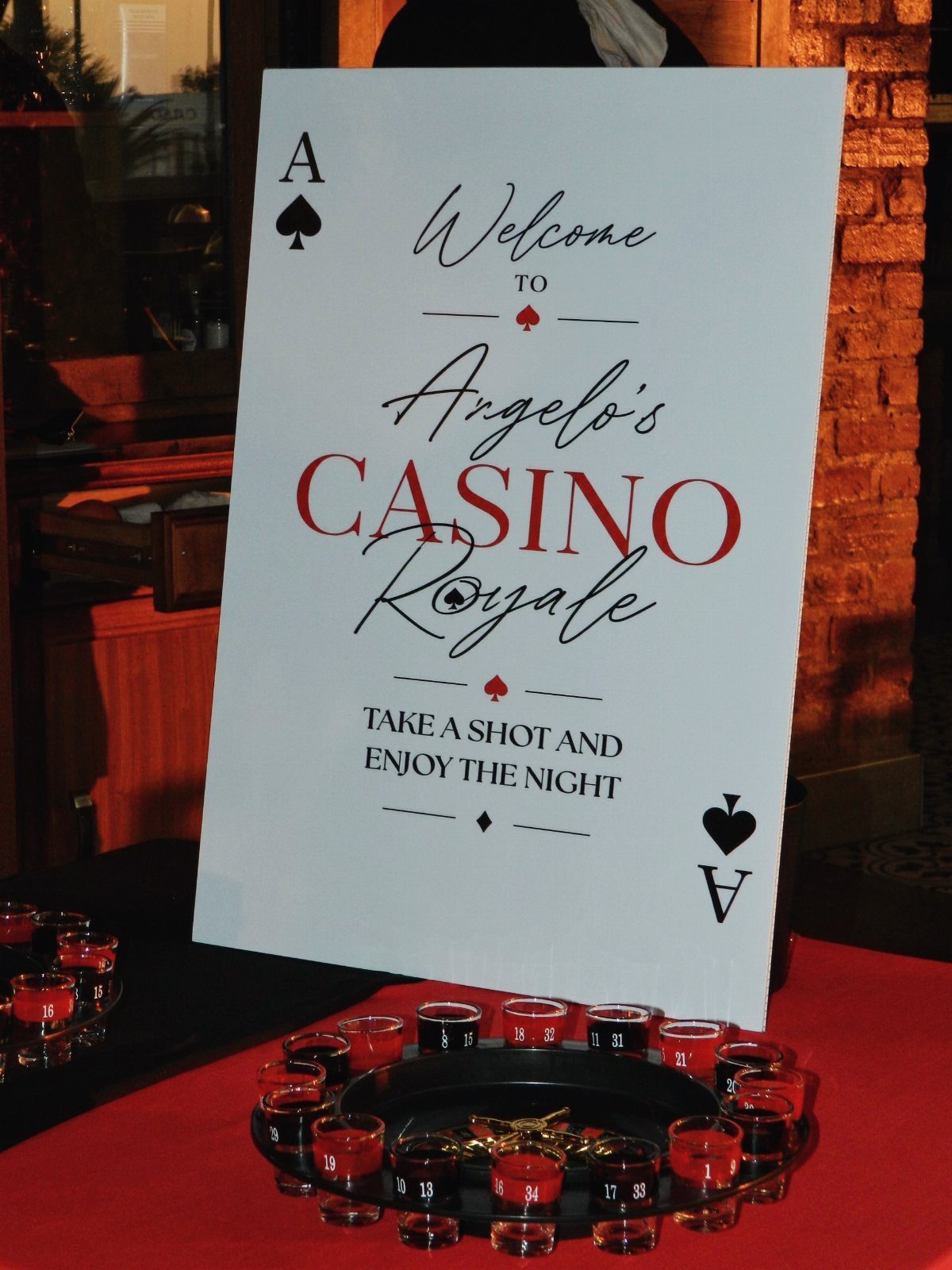 Casino Royale welcome sign next to a tray of shot glasses on red cloth