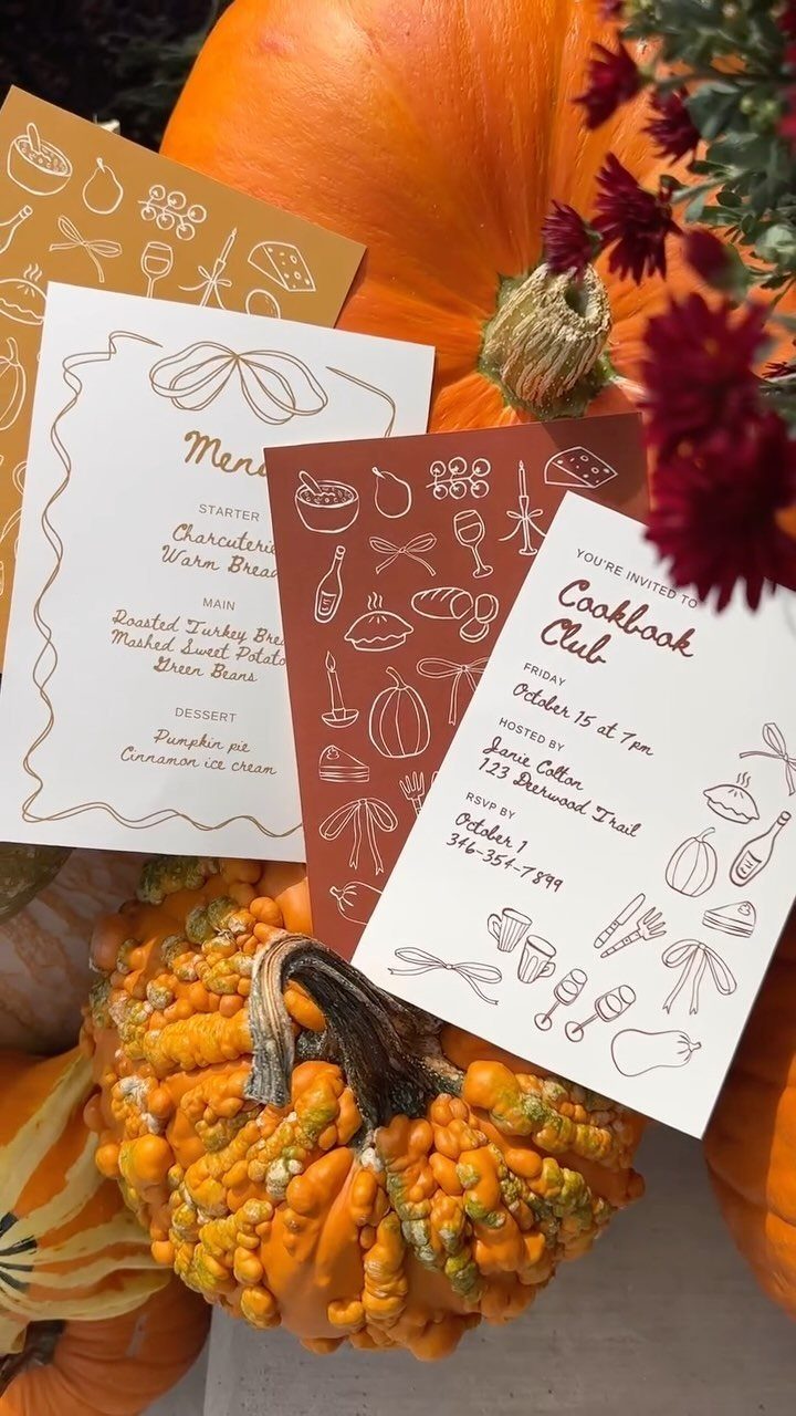 Cookbook Club invitation and menu cards surrounded by orange pumpkins and red flowers.