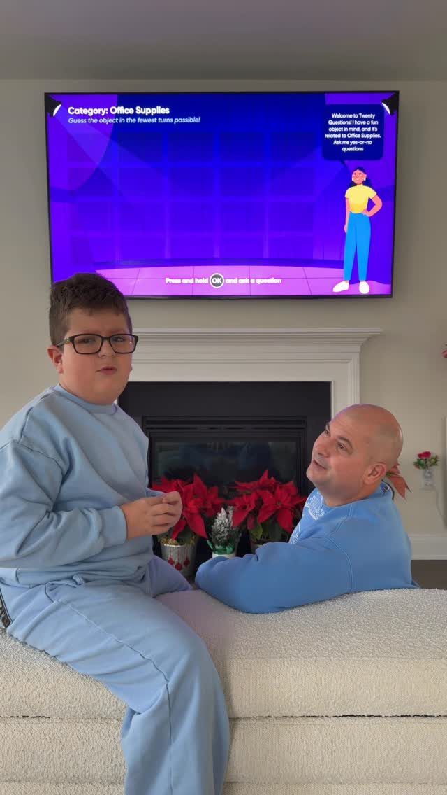 Man and boy in blue pajamas playing a video game in a living room