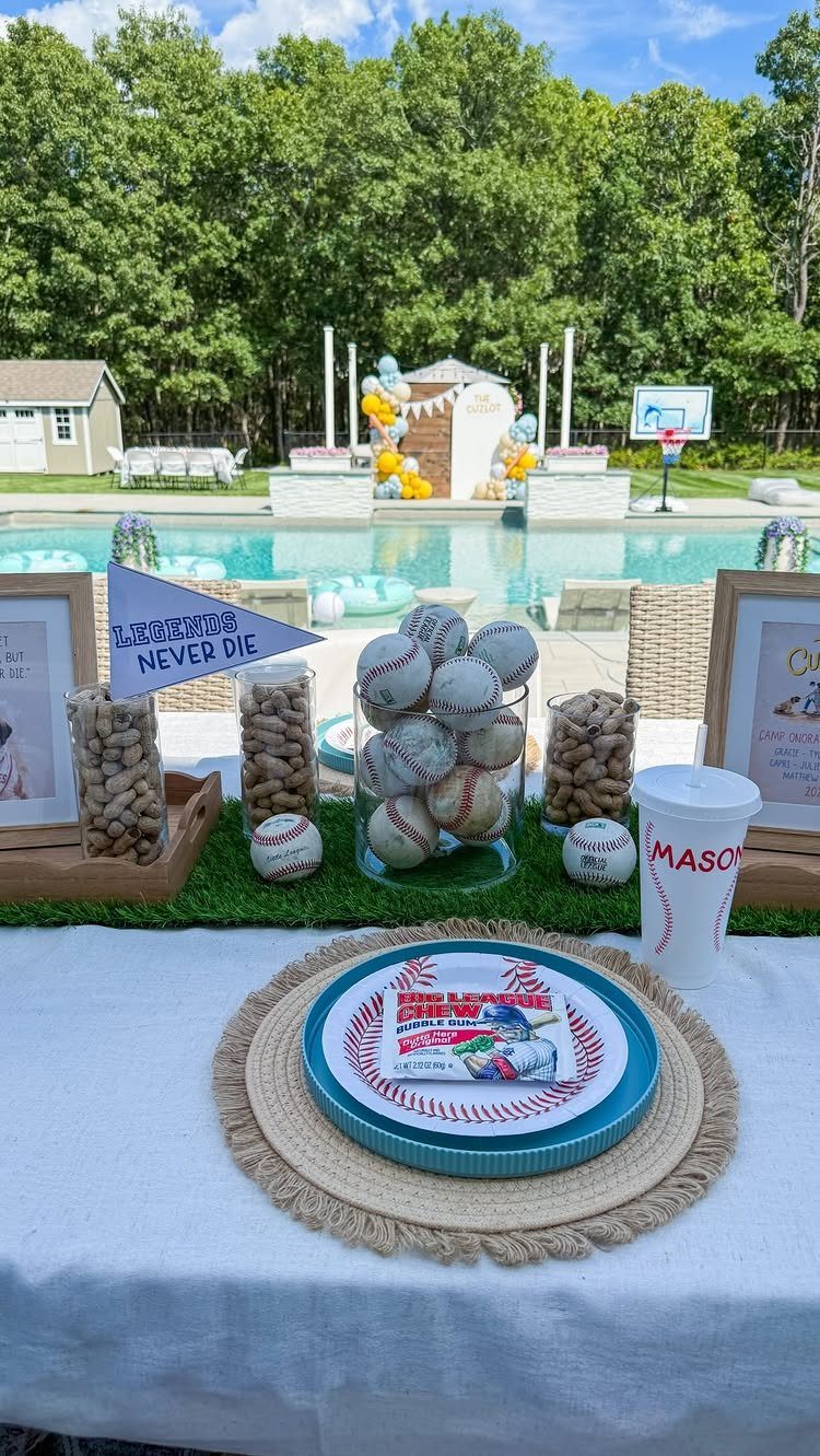Baseball themed party table setting with baseballs, pennant, and pool in background