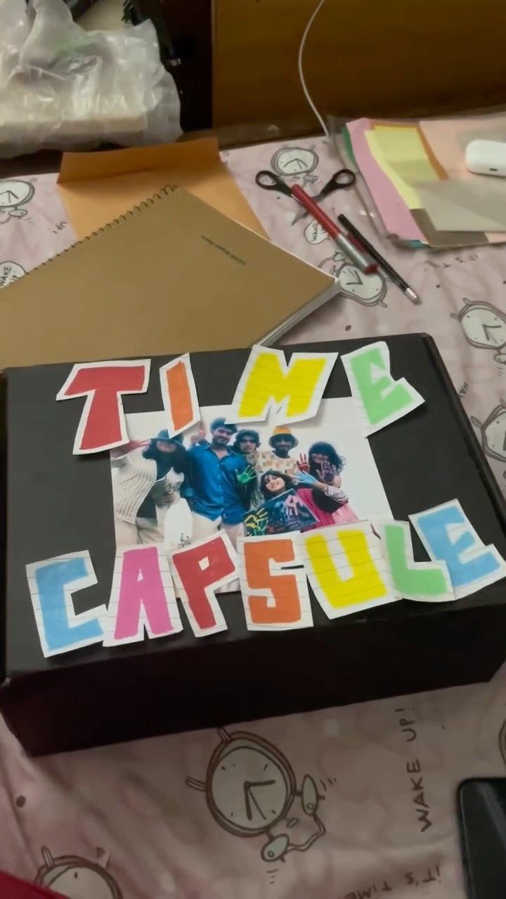 Black time capsule box decorated with colorful letters and a family group photo.