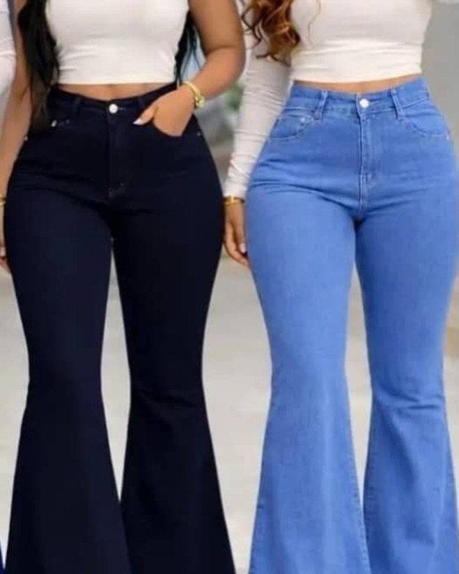 Two women wearing high-waisted flared denim jeans and fitted white crop tops.