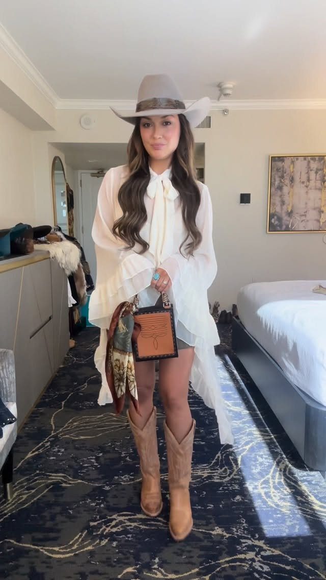 Woman in a white blouse, short skirt, tan cowboy boots, and grey hat.