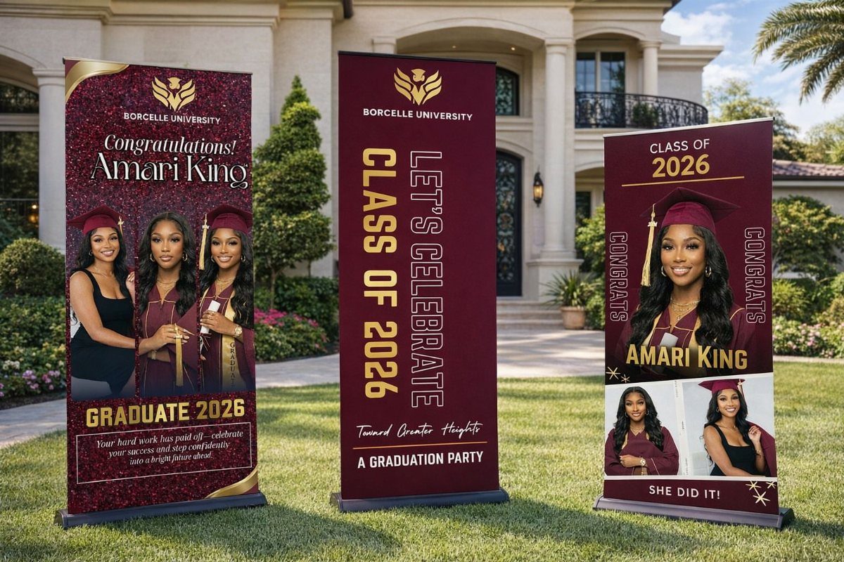 Three maroon graduation banners with photos and text standing on a green lawn.