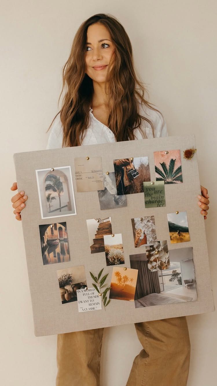 Woman holding a vision board with aesthetic photos and inspirational clippings.