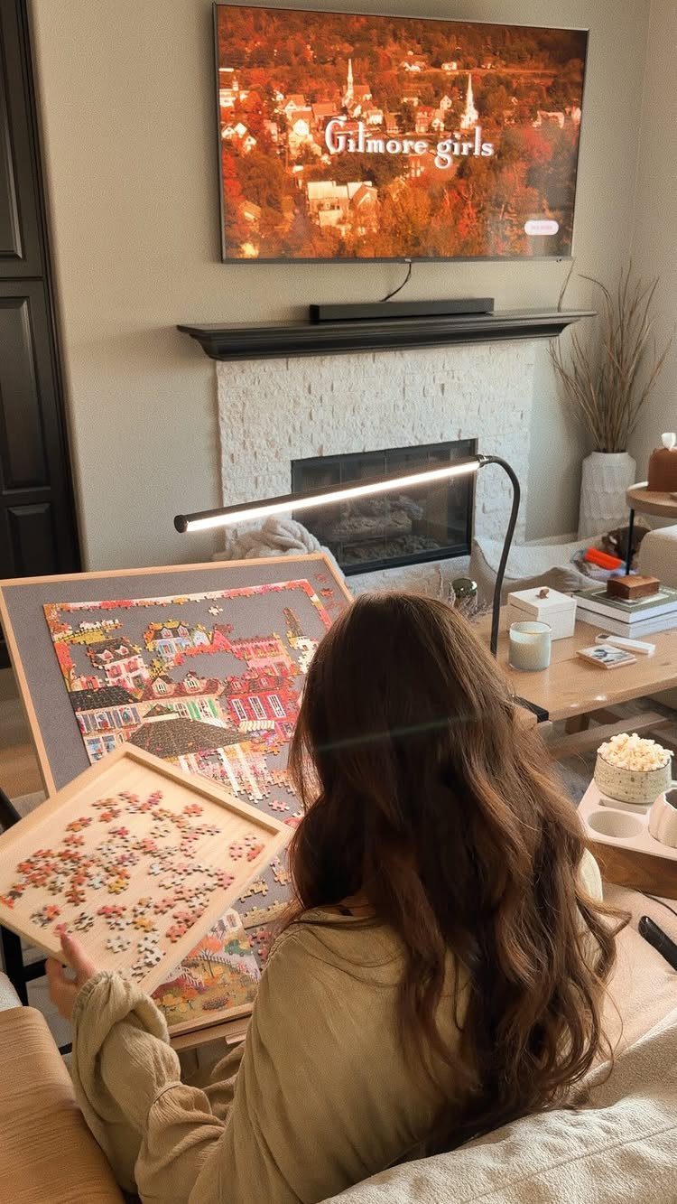 Woman assembling a colorful jigsaw puzzle in a cozy living room with a TV.