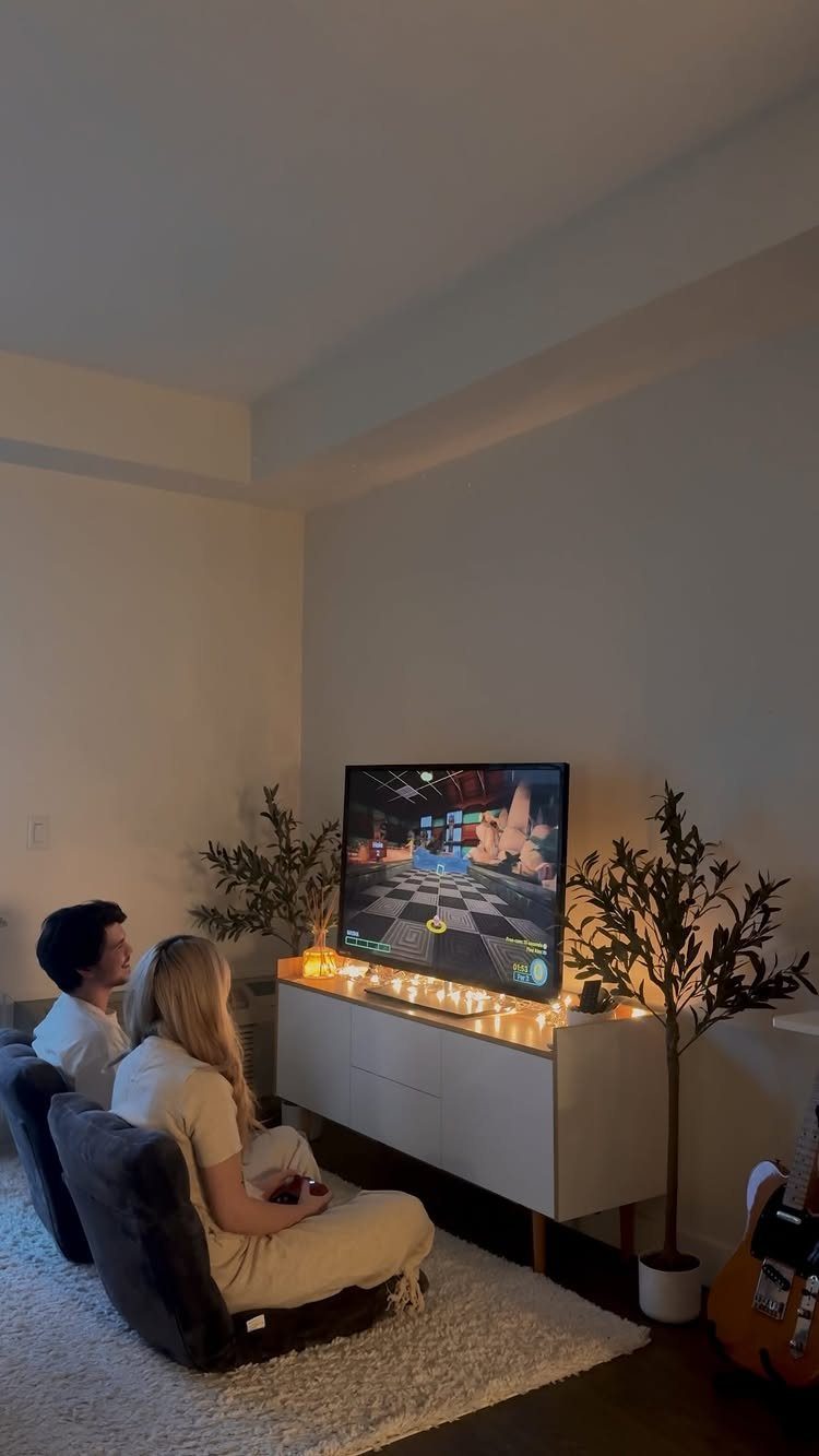Couple playing a video game on a television in a cozy living room