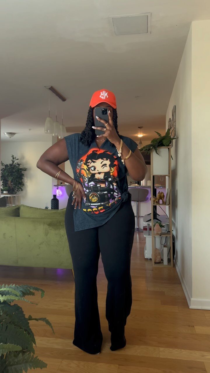 Person in red cap and graphic t-shirt posing for a mirror selfie.