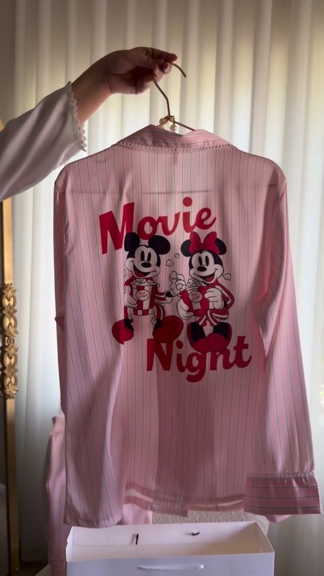 Pink striped pajama shirt with Mickey and Minnie Mouse Movie Night graphic.