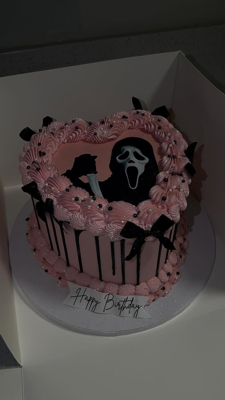 Pink heart-shaped birthday cake featuring a Ghostface silhouette and black decorative bows.