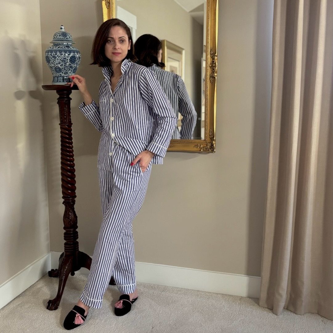 Woman wearing blue and white striped pajama set posing in a living room