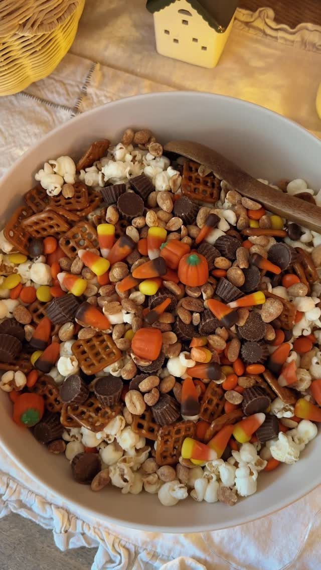 Autumn snack mix with popcorn, candy corn, and chocolate in a white bowl