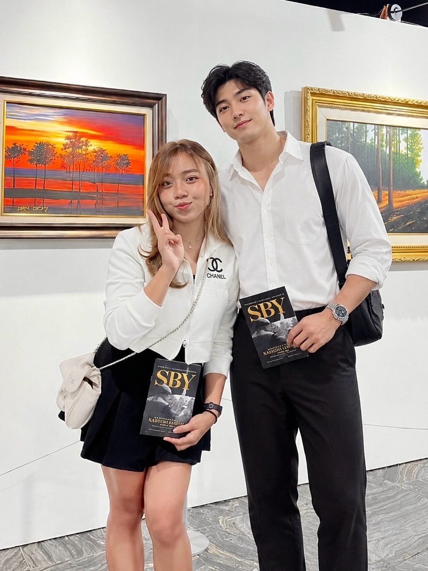Young couple posing in an art gallery with framed paintings in the background.