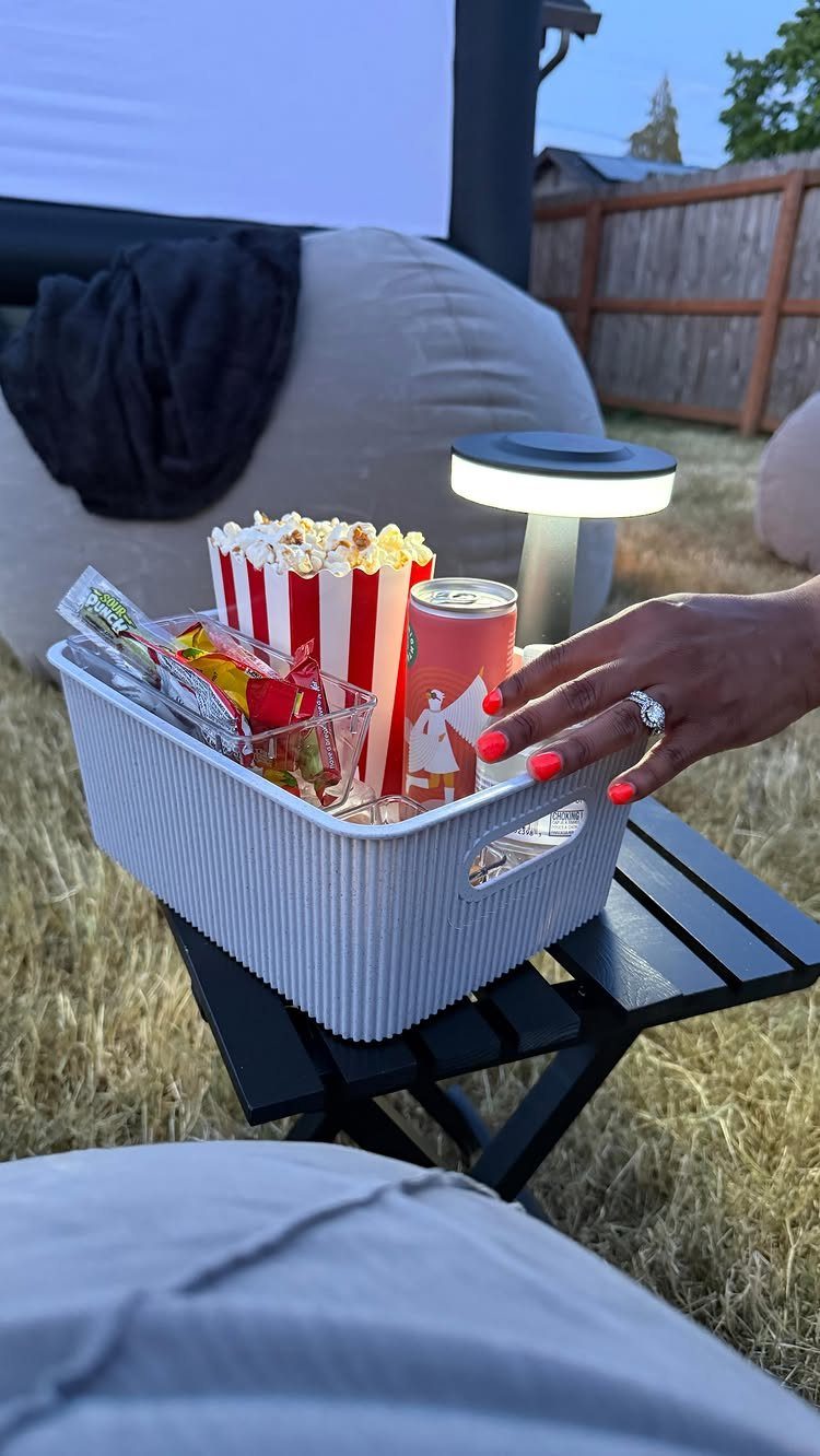 Snacks and drinks in a bin before an outdoor movie night screening.