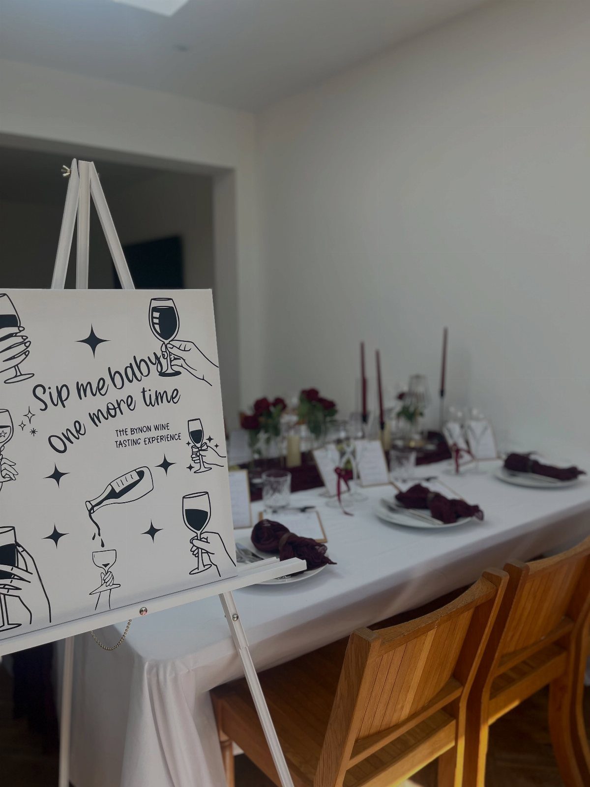 Dining table set with wine glasses and a sign saying Sip me baby
