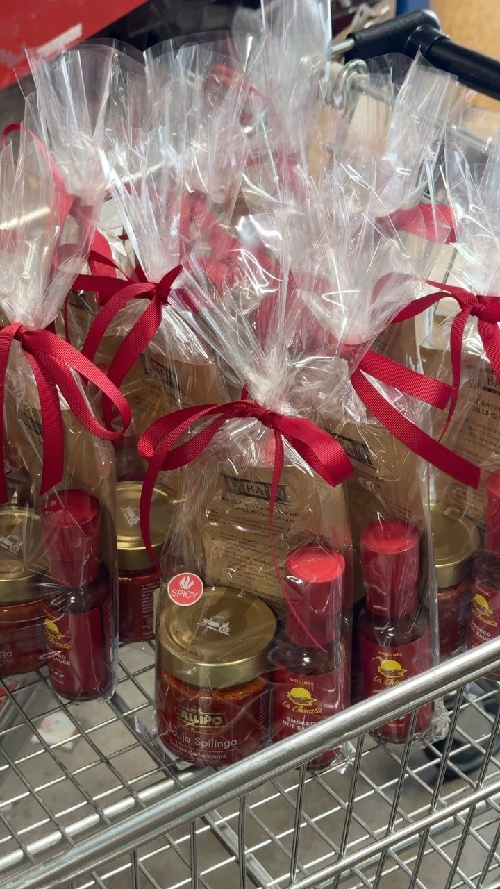 Three small jars of red hot sauce in a cellophane bag with red ribbon.