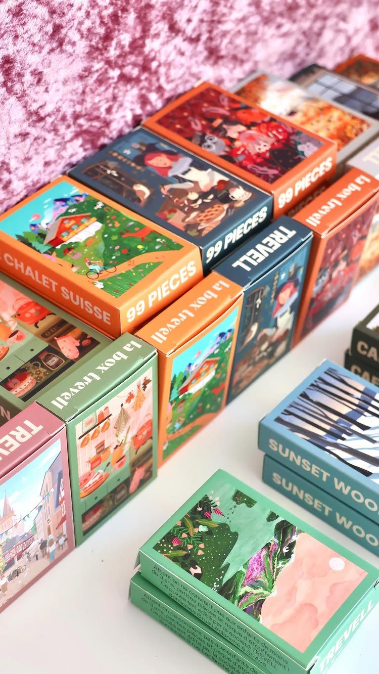 Colorful illustrated playing card decks arranged on a white surface with pink background.