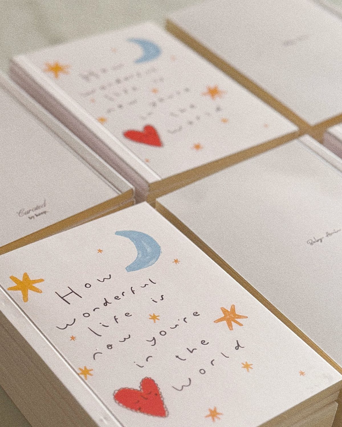 Small white notebooks with hand-drawn moons, hearts, and stars as party favors.