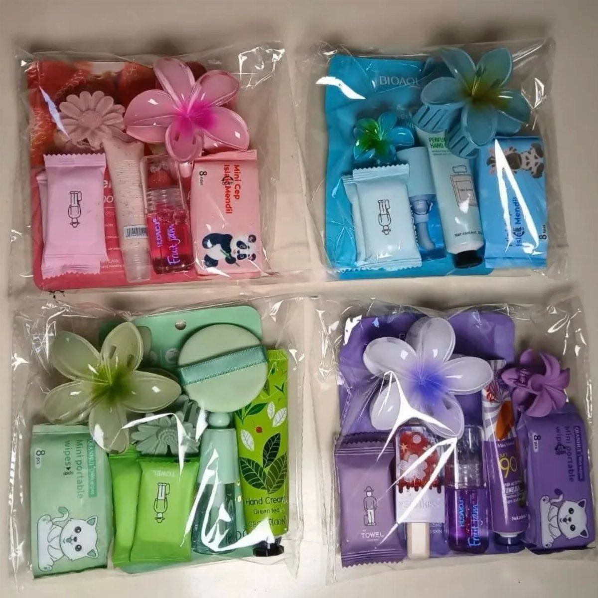 Four colorful travel-sized skincare sets in clear plastic bags with decorative flowers.