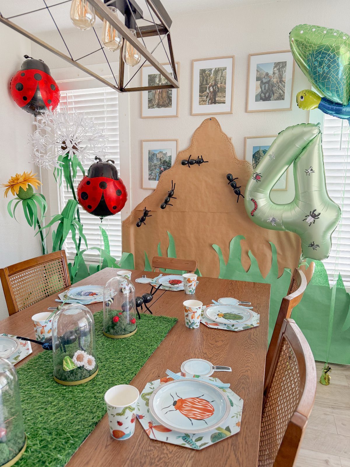 Bug-themed party decorations with ladybug balloons, a number 4 balloon, and themed tableware.